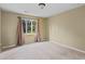 Simple bedroom featuring neutral walls, carpet and a window overlooking the back yard at 297 Northgate Trce, Roswell, GA 30075