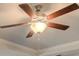 A close-up of a ceiling fan with wooden blades and light fixture, and crown molding trim at 308 Delta Dr, Mcdonough, GA 30253