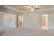 Spacious primary bedroom with neutral carpeting, tray ceiling, and access to a walk-in closet at 308 Delta Dr, Mcdonough, GA 30253