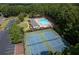 Aerial view of community pool and tennis courts surrounded by lush trees, offering recreation and leisure at 516 Huntgate Rd, Woodstock, GA 30189