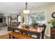 Cozy dining area with wooden table and bench seating, adjacent to living room and sunroom with backyard views at 516 Huntgate Rd, Woodstock, GA 30189