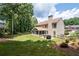 Spacious backyard with lush lawn, mature trees, an outdoor patio and screened-in porch at 516 Huntgate Rd, Woodstock, GA 30189