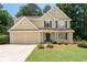 Charming two-story home featuring a well-manicured lawn and an attached two-car garage at 516 Huntgate Rd, Woodstock, GA 30189