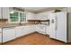 Bright kitchen with white cabinets, modern appliances, tile backsplash, and hardwood floors at 516 Huntgate Rd, Woodstock, GA 30189