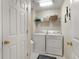 Functional laundry area with washer, dryer, storage shelf, and practical design for efficient chore management at 516 Huntgate Rd, Woodstock, GA 30189