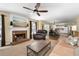 Open-concept living room featuring a brick fireplace, ceiling fan, and lots of natural light at 516 Huntgate Rd, Woodstock, GA 30189