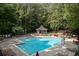 Community pool surrounded by lounge chairs and umbrellas at 516 Huntgate Rd, Woodstock, GA 30189