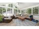 Cozy sunroom boasts a vaulted ceiling, lots of windows and a comfortable seating arrangement at 516 Huntgate Rd, Woodstock, GA 30189