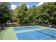 Aerial view of the tennis courts surrounded by lush greenery at 516 Huntgate Rd, Woodstock, GA 30189