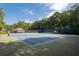 Two well-maintained community tennis courts surrounded by lush trees at 516 Huntgate Rd, Woodstock, GA 30189
