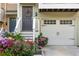 Inviting townhouse exterior featuring a garage, brown front door, and vibrant floral landscaping at 1304 Liberty Nw Pkwy # 1610, Atlanta, GA 30318