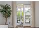 Bright airy view of the patio visible through open glass doors and a large potted plant at 1304 Liberty Nw Pkwy # 1610, Atlanta, GA 30318