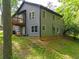 Side view of a gray two-story home featuring a walk out deck, multiple windows, and lush green landscaping at 2674 Skylane Dr, Marietta, GA 30062