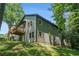 Side view of home with green siding and a deck overlooking the yard with mature trees at 2674 Skylane Dr, Marietta, GA 30062