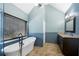 This bathroom features a soaking tub under a window, light blue walls, and a vanity with granite countertops at 3819 Trotters Run, Douglasville, GA 30135