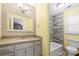 Bright bathroom with yellow walls, a tub, a vanity with drawers, and wood-look tile at 3819 Trotters Run, Douglasville, GA 30135