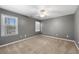 Bedroom with neutral carpet and gray walls, featuring two windows and a ceiling fan at 3819 Trotters Run, Douglasville, GA 30135