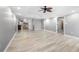 Open-concept living room with light wood floors, ceiling fan, and views of the kitchen area at 3819 Trotters Run, Douglasville, GA 30135