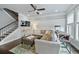 Comfortable living room features a ceiling fan, wainscotting, TV, and staircase access to the second floor at 4202 Morrison Way # 9, Atlanta, GA 30341