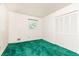A bedroom showcasing a double closet, bright window, and distinctive green carpet at 746 Gladstone Nw Rd, Atlanta, GA 30318