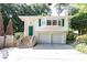Charming white home featuring a green front door, a two-car garage, and lush landscaping at 746 Gladstone Nw Rd, Atlanta, GA 30318
