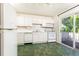 Bright kitchen with white appliances and cabinetry, plus sliding glass door to outdoor deck at 746 Gladstone Nw Rd, Atlanta, GA 30318