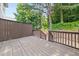 A wooden back deck with brown railing overlooks a wooded backyard at 1168 Liberty Nw Pkwy, Atlanta, GA 30318