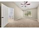 Neutral color carpeted main bedroom featuring a ceiling fan, an ensuite bathroom and a window at 1168 Liberty Nw Pkwy, Atlanta, GA 30318