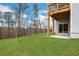 Spacious backyard with lush green grass and a view of the wooded surroundings and basement sliding glass door at 159 Sunshower Rdg, Canton, GA 30114