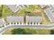 Aerial view of townhome with manicured lawns and neighborhood street at 191 Madison Bnd, Woodstock, GA 30188