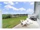 A backyard featuring a patio with white chairs, a grill, and green grass at 191 Madison Bnd, Woodstock, GA 30188
