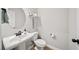 Charming powder room featuring a pedestal sink, round mirror, and neutral color palette at 191 Madison Bnd, Woodstock, GA 30188