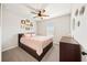Cozy bedroom with wood-look bedframe, ceiling fan, lots of pictures on wall, and a dresser at 191 Madison Bnd, Woodstock, GA 30188
