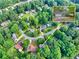 Aerial view of the property and surrounding neighborhood, showing tree coverage and house location at 241 Tweed Ct, Sugar Hill, GA 30518