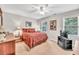 Bedroom with red bedspread, neutral walls, and natural light at 241 Tweed Ct, Sugar Hill, GA 30518