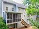 View of the house, featuring a screened-in porch, stairs, and lush landscaping at 241 Tweed Ct, Sugar Hill, GA 30518