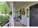 Quaint front porch showcasing decorative wreath and seating area at 241 Tweed Ct, Sugar Hill, GA 30518
