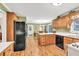 Efficient kitchen featuring wood cabinets, functional island and adjacent dining area at 241 Tweed Ct, Sugar Hill, GA 30518