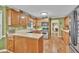 Bright kitchen featuring wood cabinets, a functional layout, and adjacent access to other rooms at 241 Tweed Ct, Sugar Hill, GA 30518