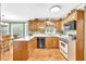 Traditional kitchen with wood cabinets, appliances, and breakfast nook area at 241 Tweed Ct, Sugar Hill, GA 30518