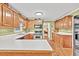 Well-lit kitchen with ample counter space, oak cabinetry, and a view to adjoining rooms at 241 Tweed Ct, Sugar Hill, GA 30518