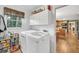 Bright laundry room with front loading machines and storage shelves, next to the kitchen at 241 Tweed Ct, Sugar Hill, GA 30518