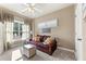 Bedroom is furnished with a comfortable sofa, soft ottoman, and bright window at 5029 Rosalie Rd, Johns Creek, GA 30022