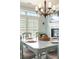 Dining area showcasing a wooden table setting, neutral-toned chairs, and a decorative chandelier at 5029 Rosalie Rd, Johns Creek, GA 30022