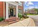 Charming front entrance with brick steps, black door, and lush landscaping at 5029 Rosalie Rd, Johns Creek, GA 30022