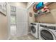 Well-organized laundry room featuring a side-by-side washer and dryer and shelving at 5029 Rosalie Rd, Johns Creek, GA 30022