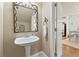 Stylish powder room with pedestal sink, decorative mirror, and doorway to dining area at 5029 Rosalie Rd, Johns Creek, GA 30022