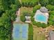 Aerial view of a community pool, tennis court, and play area surrounded by beautiful trees at 895 Mill Garden Pl, Cumming, GA 30040