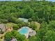 Aerial view of a beautiful pool, tennis court, and play area surrounded by lush trees at 895 Mill Garden Pl, Cumming, GA 30040