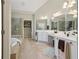 Elegant bathroom with a soaking tub, glass shower, and double vanity sinks at 895 Mill Garden Pl, Cumming, GA 30040